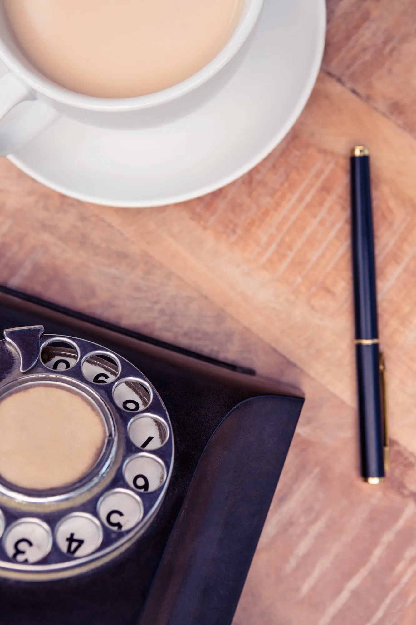 Šálek kávy, pero a starý telefon na stole